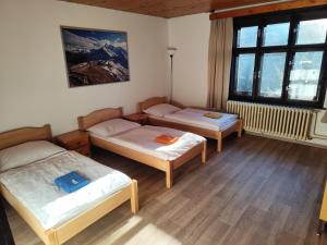 een kamer met drie bedden en een raam bij Pension 21 in Praag