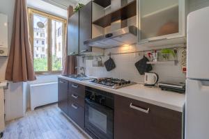 una cucina con fornello forno superiore accanto a una finestra di Typical & Cozy Apartment - Testaccio - Trastevere a Roma