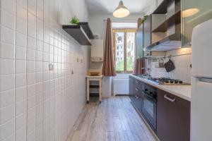 una cucina con piastrelle bianche sul muro e piano cottura di Typical & Cozy Apartment - Testaccio - Trastevere a Roma Altre 34 foto