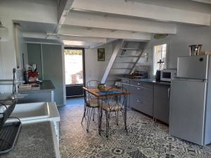eine Küche mit einem Tisch und einem Kühlschrank in der Unterkunft LAMATHYE in Aramon