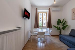 un soggiorno con un tavolo e un divano blu di Typical & Cozy Apartment - Testaccio - Trastevere a Roma