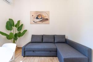 un divano blu in soggiorno con una pianta di Typical & Cozy Apartment - Testaccio - Trastevere a Roma