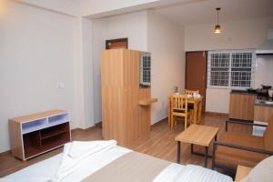 a bedroom with a bed and a kitchen with a table at Lake Breeze Apartment in Pokhara