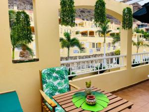 a table and chairs on a balcony with a view of a building at Casa Melo by SunHousesCanarias in Puerto de Mogán