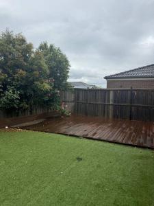 a backyard with a wooden deck and a fence at The Blissful Abode in Truganina