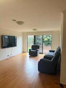 a living room with two couches and two chairs at The Blissful Abode in Truganina