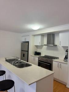 a kitchen with a sink and a stove top oven at The Blissful Abode in Truganina