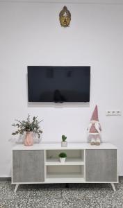 un centro di intrattenimento bianco con una TV a schermo piatto su una parete bianca di Casa Amador a Hinojosa del Duque