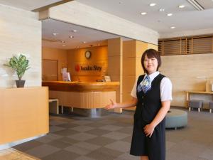 a woman standing in front of a lobby at Juraku Stay Niigata in Niigata
