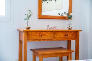a wooden table with two vases with flowers on it at C'an Vidal apto Menorca in Colonia Sant Jordi