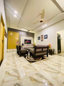 a living room with a couch and a table and chairs at Comfy Cottage in Faisalabad
