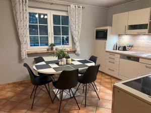 a kitchen with a table and chairs in a room at FeWo Naturblick mitten im schönen Cuxland Perfekt für Familien mit Hunden in Stinstedt