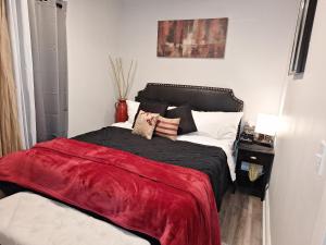 a bedroom with a bed with a red blanket on it at St Paul Fry Street Den Suite#1 in Saint Paul