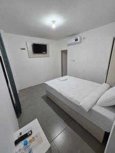 a bedroom with a bed and a tv on the wall at Achazia Homestay in Labuan Bajo