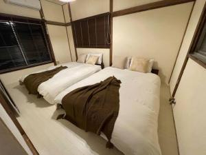 two beds in a small room at 桜木町 鶴 古民家の宿 in Nishi-hiranumachō