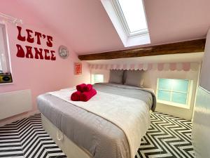a bedroom with a bed with a teddy bear on it at Chambre Disco Paradisio in Sélestat