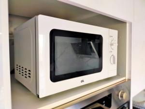 eine Mikrowelle auf einem Regal in einer Küche in der Unterkunft Moderno Atico Loft en Peñíscola Centro, cerca de la Playa y el Castillo Papa Luna in Peñíscola