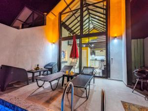 ein Wohnzimmer mit Stühlen, Tischen und einem Pool in der Unterkunft Villa Migala-1 in Bezirgân