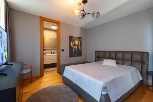 a bedroom with a large bed and a television at Villa Bella in Sarajevo +20 photos