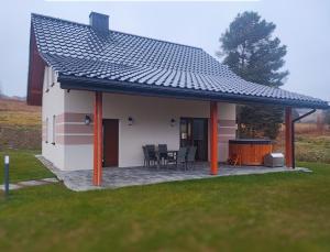 a house with a pitched roof with a patio at Kopanicówki in Jaworzynka