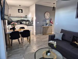 a living room and kitchen with a couch and a table at Apartament Cinema in Mielno
