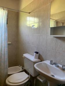 a bathroom with a toilet and a sink at INTI MAYU Cabañas in Mina Clavero
