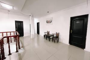 a hallway with black doors and a table and chairs at Scala Inn By Helocus in Medan