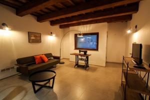 a living room with a couch and a flat screen tv at Casa Sartoria - Guest House in Pergola