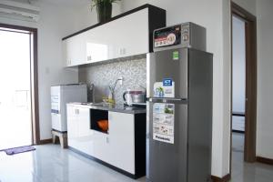 a kitchen with a refrigerator and a counter at Nha Trang Seaview Penthouse Apartment in Nha Trang