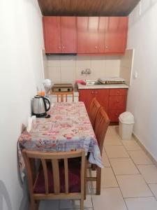 una cucina con tavolo e sedie e una cucina con armadi rossi di Matenia’s house a Mángana