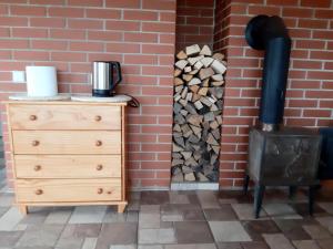 a stack of fire wood next to a brick wall at Marių Kalvos in Palėvenėlė +21 photos