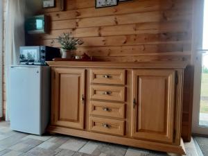 a kitchen with wooden cabinets and a refrigerator at Marių Kalvos in Palėvenėlė