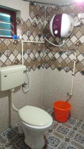 a bathroom with a toilet and a hair dryer at Aamis Home Stay in Vattavada