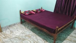 a purple bed with two pillows on it at Aamis Home Stay in Vattavada