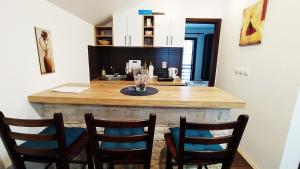 eine Küche mit einer Theke mit vier Stühlen drum herum in der Unterkunft Apartman Draškovic - Goč in Biserske Kuće + 22 Fotos