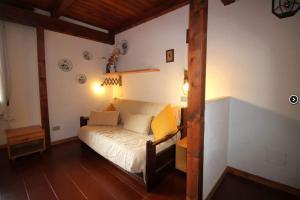 a bedroom with a white bed with yellow pillows at Appartamento Sestriere in Sauze di Cesana