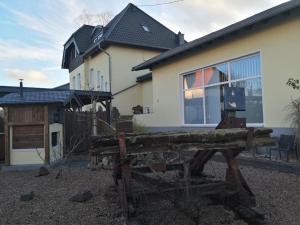 a wooden bench in front of a house at Gemütliches Loft mit Terrasse im ehemaligen Bahnhof Kalenborn in Vettelschoß