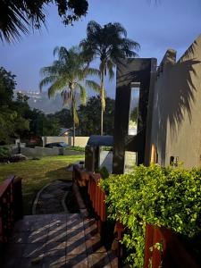 a building with a fence and palm trees in the background at Luband Stelties in Nelspruit