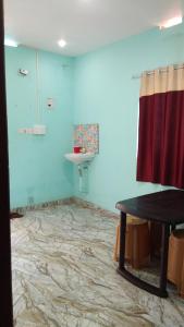 a room with a bathroom with a sink and a table at Aamis Home Stay in Vattavada