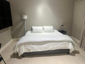 a bedroom with a large bed with white sheets and pillows at Luband Stelties in Nelspruit