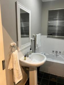 a white bathroom with a sink and a tub at Luband Stelties in Nelspruit +7 photos