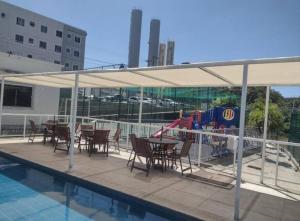 a patio with tables and chairs and a playground at Apto mobiliado e aconchegante - 3 quartos e 4 camas - Lazer completo e localização privilegiada in João Pessoa +36 photos