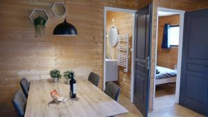 a dining room with a wooden table and chairs at Camping & Chalets La Santoire in Saint-Bonnet-de-Condat +17 photos