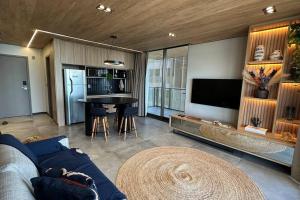 un salon avec un canapé bleu et une table dans l'établissement Apto Luxo Beira-Mar com Varanda de Frente para o Mar da Praia de Pajuçara NT1207, à Maceió