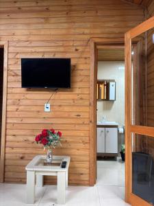 a living room with a vase of flowers on a table at Morada da Lagoa in Garopaba +28 photos