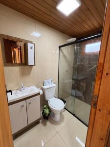 a bathroom with a toilet and a glass shower at Morada da Lagoa in Garopaba +28 photos