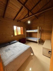 a bedroom with two bunk beds in a cabin at Morada da Lagoa in Garopaba