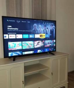 a flat screen tv sitting on top of a white cabinet at La Maison Verte in Tulette
