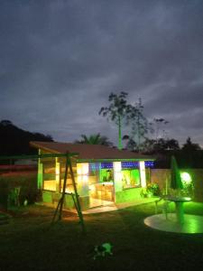 a house lit up at night with a playground at Chalés Luz Da Lua in Caraguatatuba