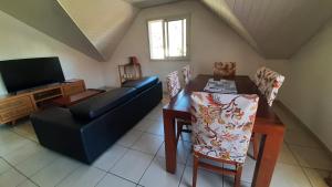 a living room with a couch and a table and a television at Chez nous ! in Cilaos